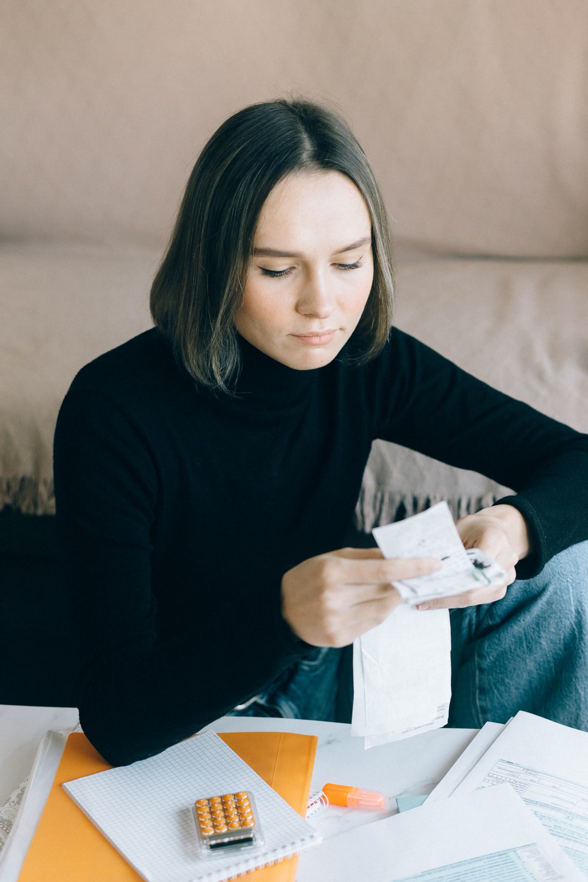 Pet owner reviewing veterinary bills and insurance documents with their dog at the kitchen table