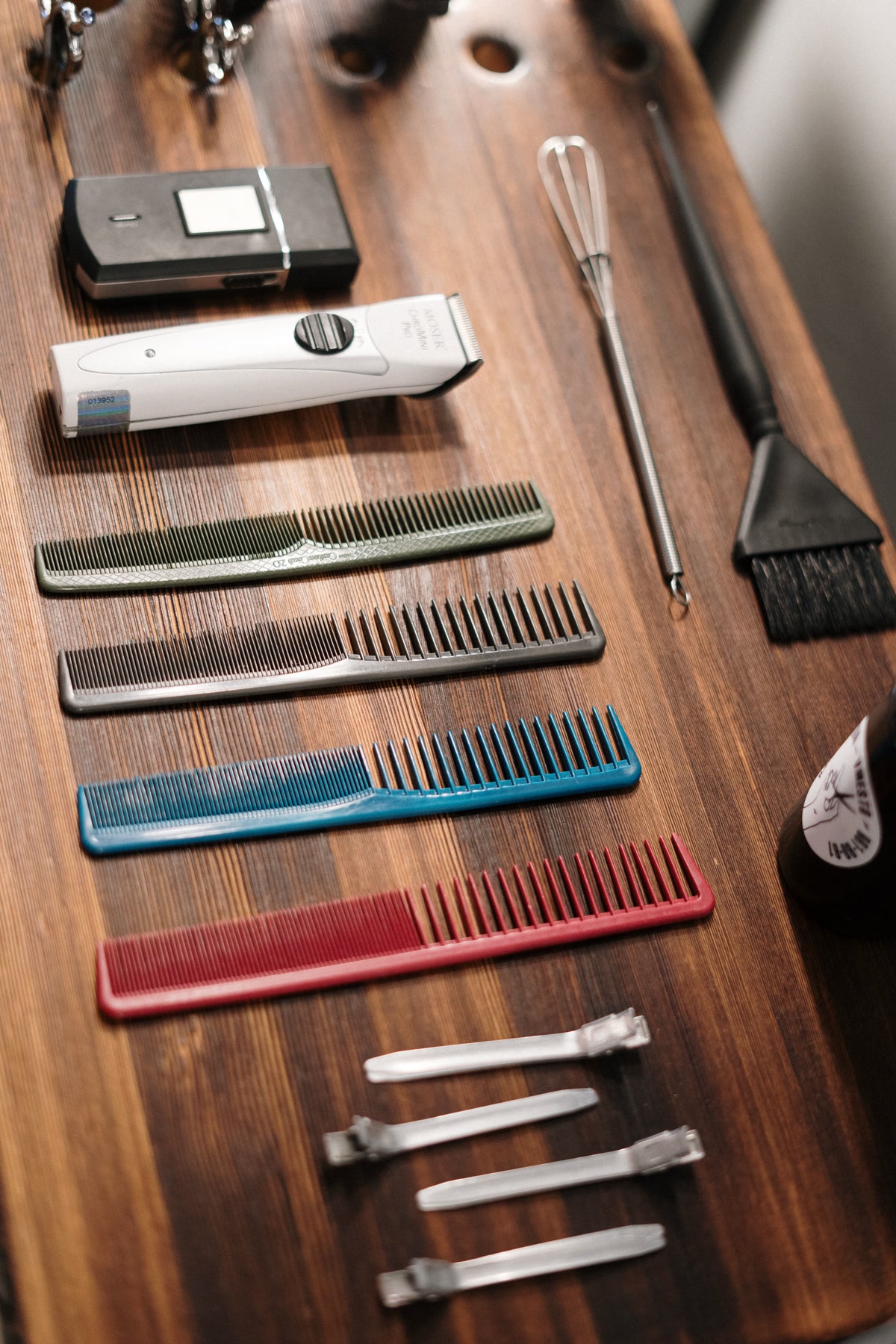 Flat lay of dog grooming tools arranged on a wooden table