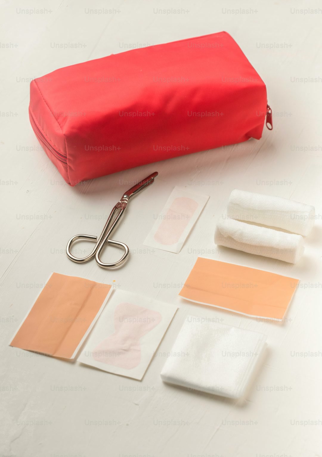 a red bag sitting on top of a table next to a pair of scissors