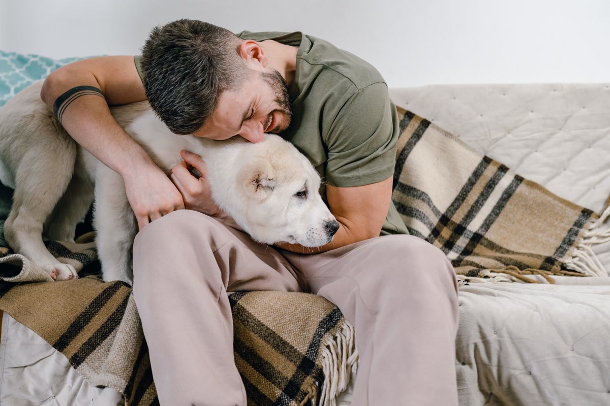 Person comforting and hugging dog during storm anxiety