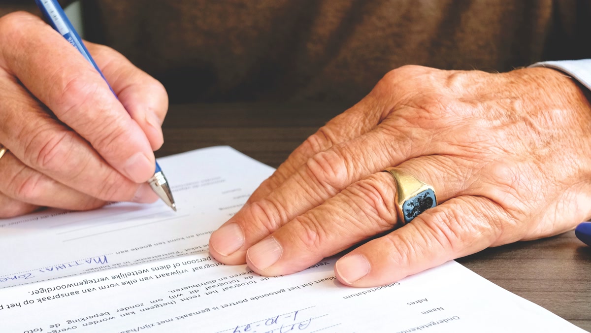 Hands signing adoption paperwork document with pen for pet adoption fees