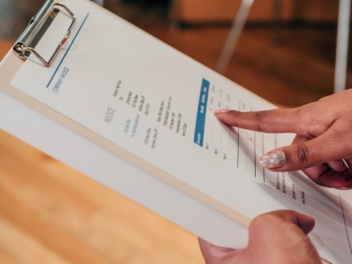 Hand pointing at veterinary invoice bill showing pet medical costs