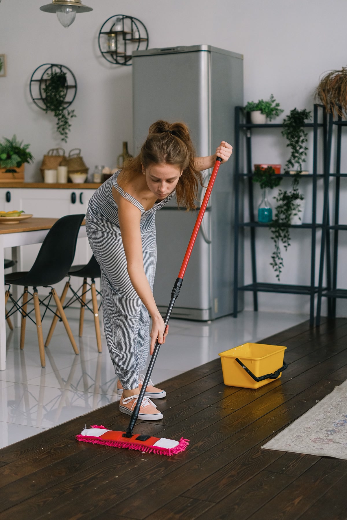 Woman cleaning floor with mop and bucket for accident cleanup